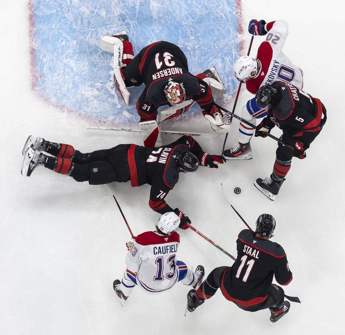 Carolina Hurricanes defenseman Jacoob Slavin (74) dives in front of goalie Frederik Andersen (31) to stop a scoring attempt by Montreal right wing Cole Caufield (13) and left wing Juraj Slafkovsky (20) in the first period in Game 5 of the Eastern Conference Finals on Friday, May 29, 2026 at Lenovo Center in Raleigh, N.C.