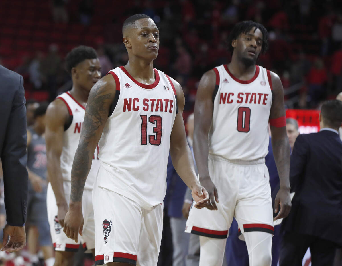 From left, N.C. State’s Markell Johnson (11) , C.J. Bryce (13) and D.J. Funderburk (0) walk off the court after Louisville’s 77-57 victory over N.C. State at PNC Arena in Raleigh, N.C., Saturday, Feb. 1, 2020.