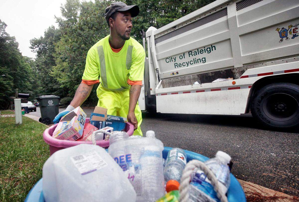 A Raleigh’s solid waste services worker collects recycling in a north Raleigh neighborhood in 2023.