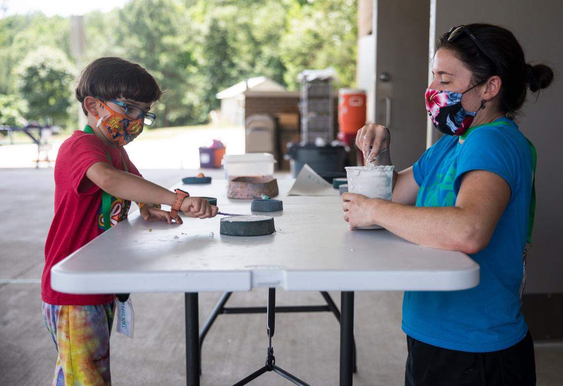 Erin Hoerner, right, who teaches special education at Glenn Elementary School during the school year, helps Jackson Wilfong, 6, make a plaster mold at The Hub Farm, an outdoor learning center in Durham, N.C., on Monday, June 21, 2021. At The Hub Farm, next door to Eno Valley Elementary School, students who did not struggle academically during the school year participate in outdoor learning activities.