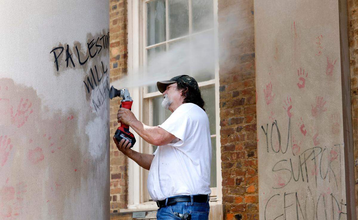 Workers clean off graffiti from the South Building at UNC Chapel Hill Saturday afternoon May 11, 2024.