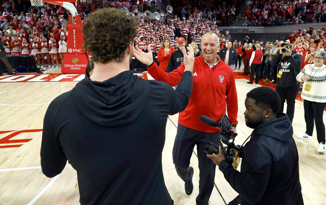 N.C. State head football coach Dave Doeren congratulates linebacker Payton Wilson after Wilson learned he won the Butkus Award during a timeout in the Wolfpack’s basketball game against Maryland Eastern Shore at Reynolds Coliseum in Raleigh, N.C., Wednesday, Dec. 6, 2023.