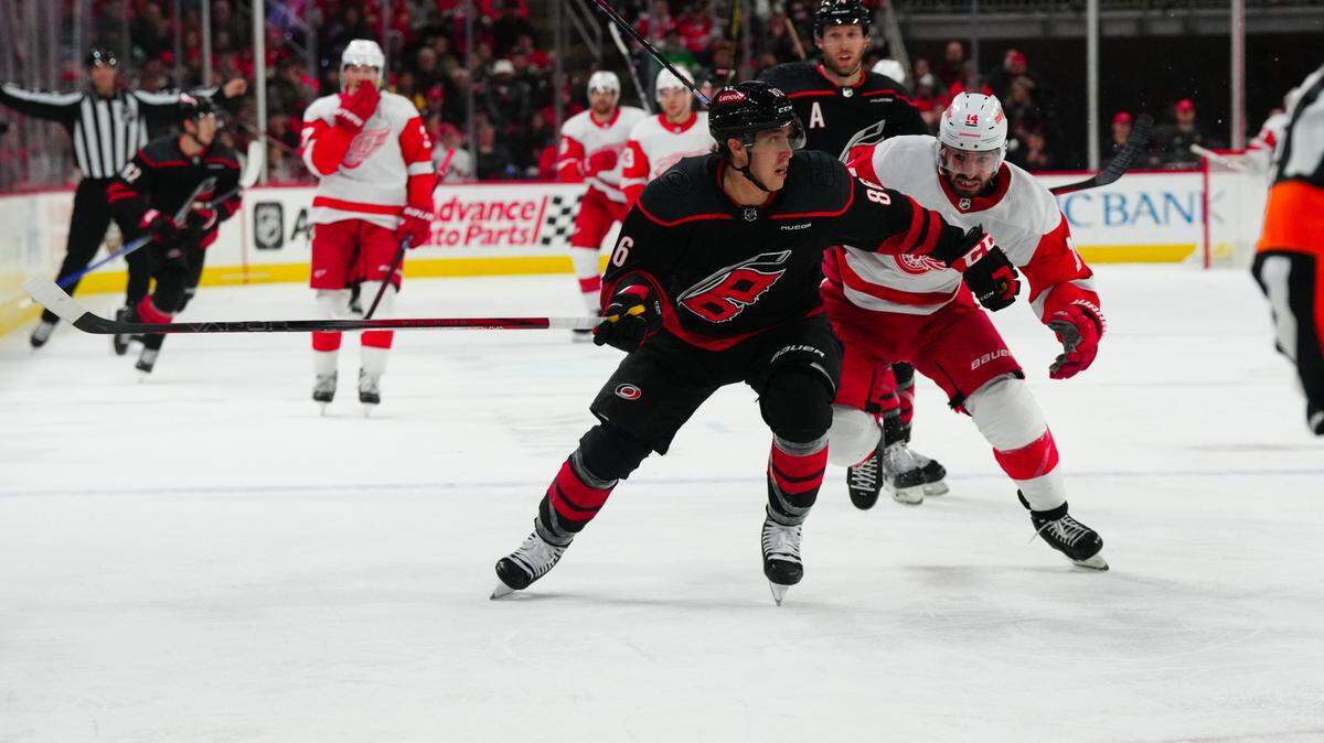 Jan 19, 2024; Raleigh, North Carolina, USA; Carolina Hurricanes left wing Teuvo Teravainen (86) and Detroit Red Wings center Robby Fabbri (14) chase after the puck during the second period at PNC Arena. Mandatory Credit: James Guillory-USA TODAY Sports