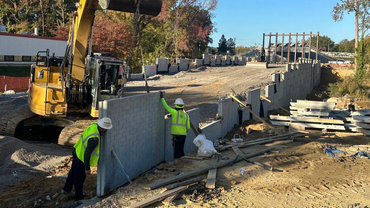 Workers place one of more than 600 concrete panels that will hold the approach to a new bridge to carry Ligon Street over the Raleigh Beltline. Photo taken Oct. 30, 2024.