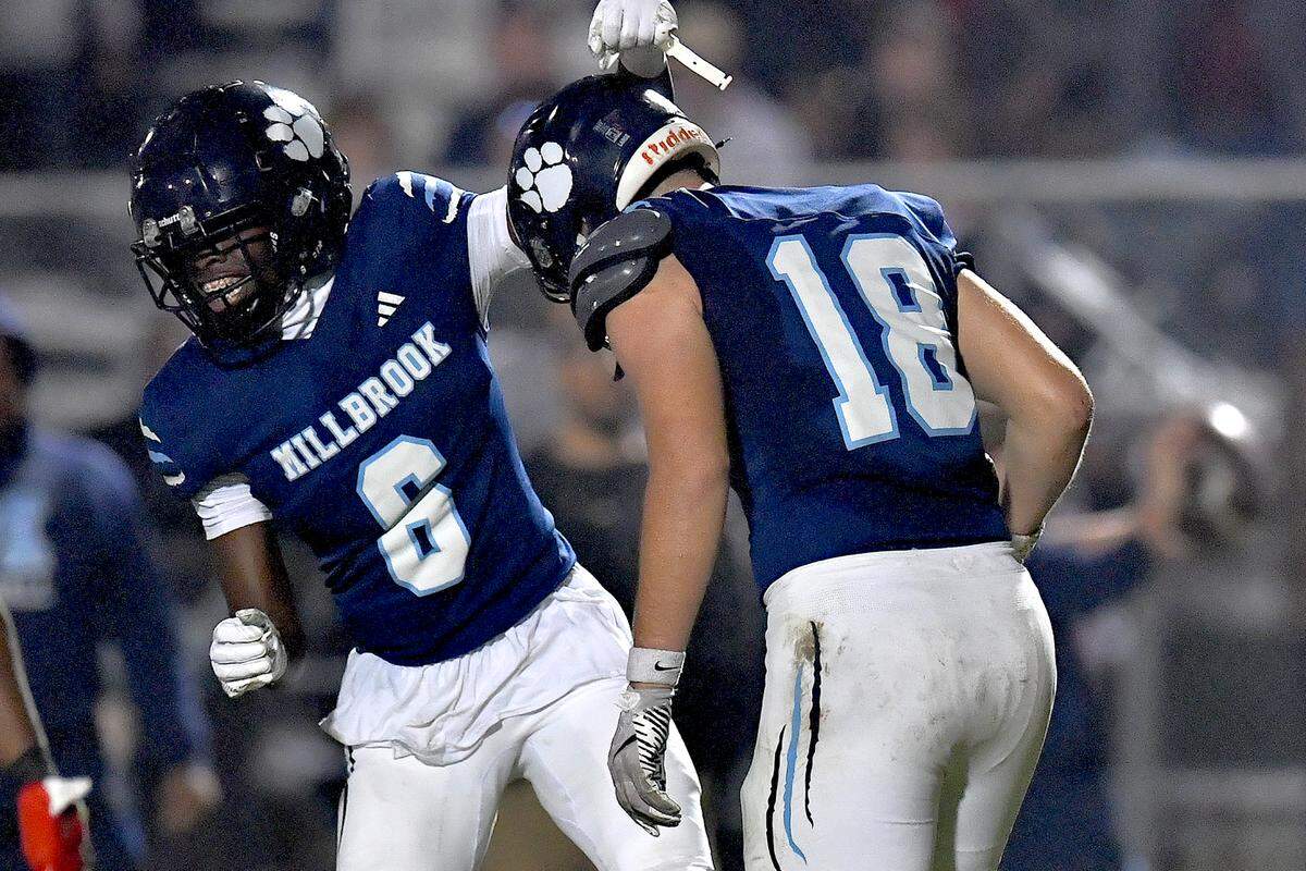 Millbrook's Hayes Brawner (18) celebrates his touchdown with Malachi Thomas (6) during the first half against Durham Jordan. The Millbrook Wildcats and the Jordan Falcons met in the third round of the NCHSAA 8A football playoffs in Raleigh, N.C. on November 21, 2025. 