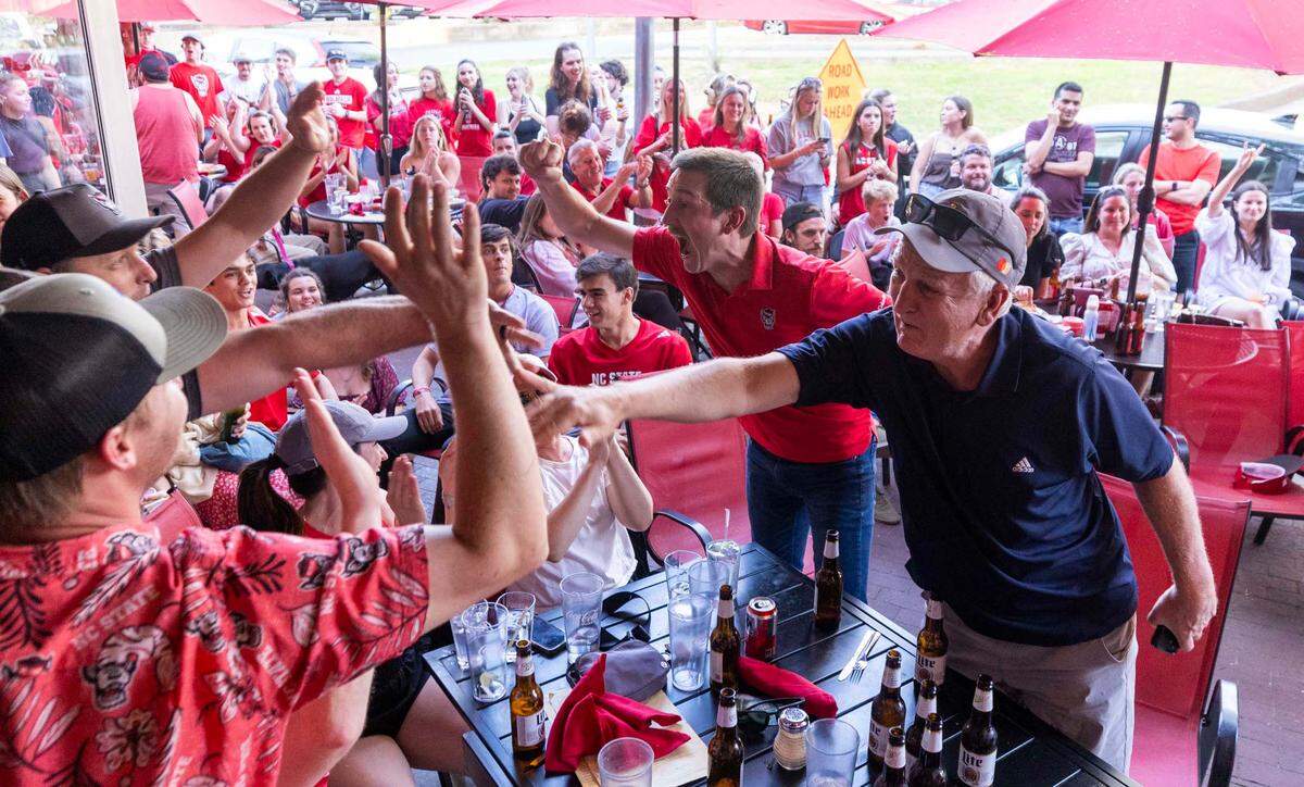NC state fans at Players’ Retreat in Raleigh celebrate a Wolfpack lead against Duke during the second half of the Elite Eight round of the NCAA Men’s Division I Basketball Tournament on Sunday, March 31, 2024.