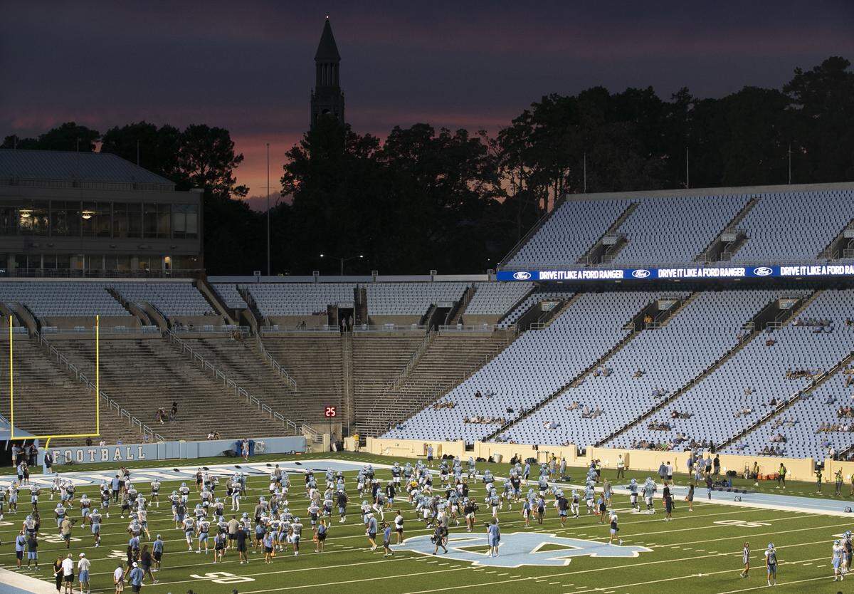Darkness falls over Kenan Stadium as the sun sets behind the Bell Tower during the Tar Heels’ practice on Monday August 19, 2019 in Chapel Hill, N.C.