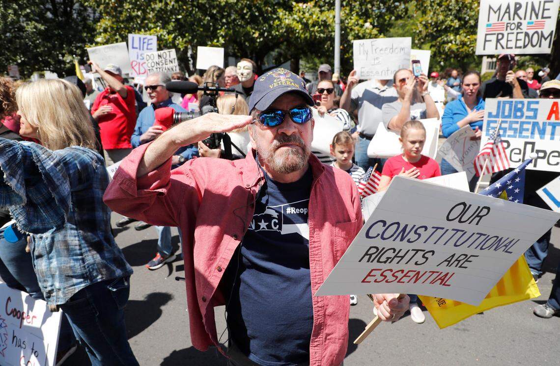 Demonstrators recite the Pledge of Allegiance outside the North Carolina Executive Mansion during a ReOpenNC protest outside the mansion in downtown Raleigh, N.C., Tuesday, May 12, 2020.