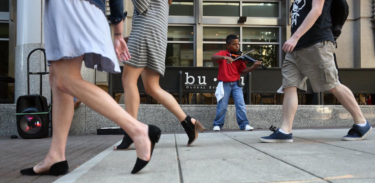 Tyler Butlet-Figueroa entertains the lunch crowd in downtown Raleigh Thursday, October 4, 2018. The eleven year old musician is on his two week break from year round school Walnut Creek Elementary and taking advantage of the fall weather to raise money for a chance to audition in Charlotte on America’s Got Talent come December.