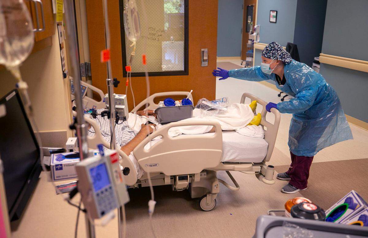 A team of nurses and respiratory therapists move a patient into the intensive care unit at Johnston UNC Health Care on Thursday, Aug. 19, 2021 in Clayton, N.C. The 10-bed intensive care unit is completely full of COVID-19 patients.
