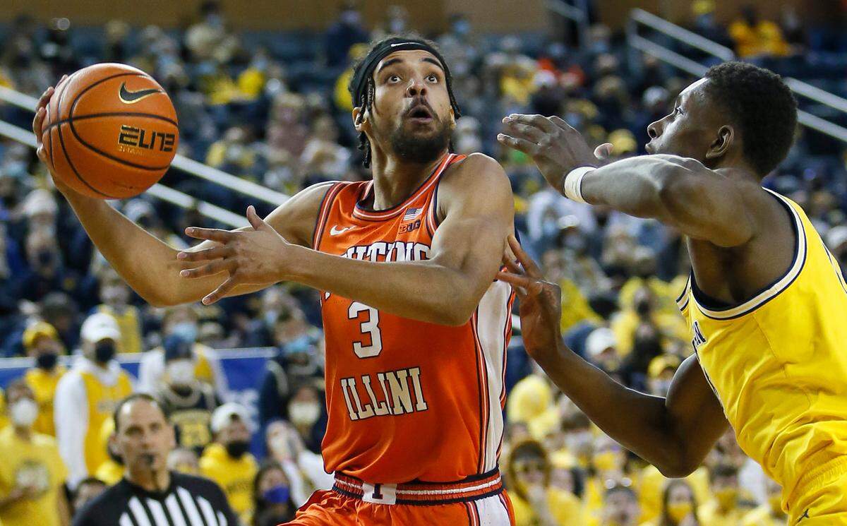Illinois’ Jacob Grandison (3) takes a shot as Michigan forward Moussa Diabate defends during their game Sunday, Feb. 27, 2022, in Ann Arbor, Mich.