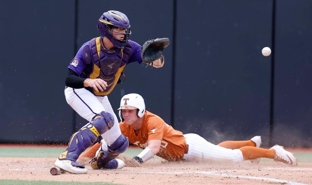 Texas Eric Kennedy (30) beats the throw to score as East Carolina’s Ben Newton (24) waits for the ball in the first inning during ECUs game against Texas in the Greenville Super Regional at Clark-LeClair Stadium Saturday, June 11, 2022.