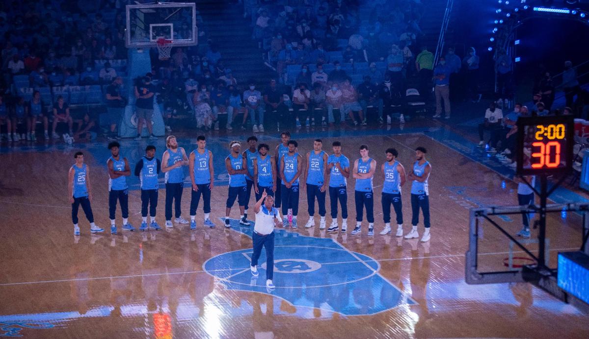 North Carolina coach Hubert Davis points to the championship banners in the Smith Center as he addresses the crowd during the annual Carolina Basketball Late Night event to start the 2021-22 basketball season on Friday, October 15, 2021 in Chapel Hill, N.C.