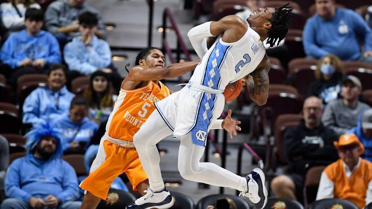 Tennessee’s Zakai Zeigler (5) reaches for the ball as North Carolina’s Caleb Love (2) drives to the basket in the first half of an NCAA college basketball game, Sunday, Nov. 21, 2021, in Uncasville, Conn. (AP Photo/Jessica Hill)