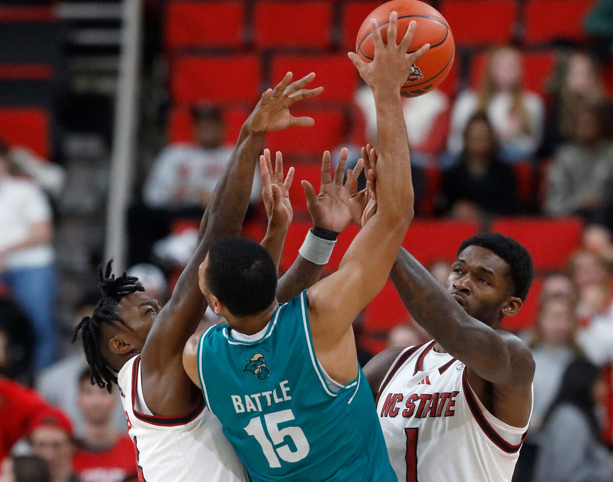 N.C. State’s Trey Parker and Brandon Huntley-Hatfield pressure Coastal Carolina’s Jordan Battle during the second half of the Wolfpack’s 82-70 win on Wednesday, Nov. 13, 2024, at Lenovo Center in Raleigh, N.C.
