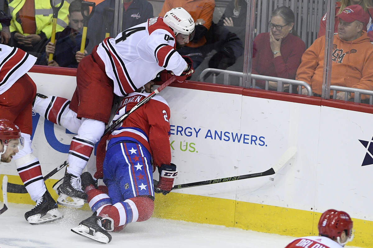 Washington Capitals defenseman Matt Niskanen (2) goes into the boards against Carolina Hurricanes center Clark Bishop (64) during the third period of an NHL hockey game, Thursday, Dec. 27, 2018, in Washington. (AP Photo/Nick Wass)