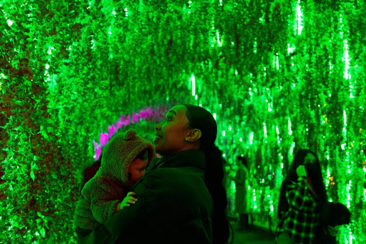 Deiara Frye, right, holds her four-month-old Samaiha Frye as they visit the Chinese Lantern Festival at Koka Booth Amphitheatre in Cary on Wednesday evening, Dec. 22, 2021.