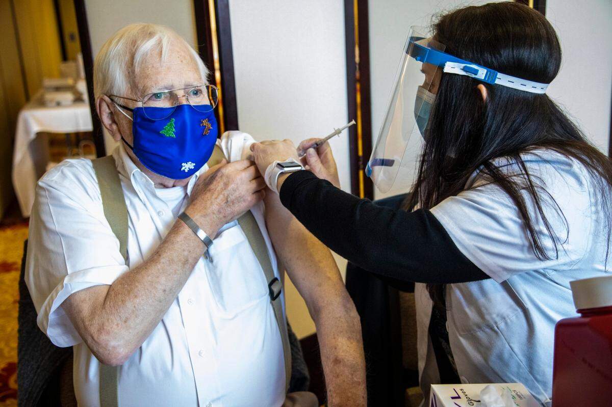 Pharmacist Holly Sawin, right administers a coronavirus vaccine to John ONeil, 86, at Searstone Retirement Community in Cary Monday, Dec. 28, 2020. About 350 residents and employees were vaccinated Monday.