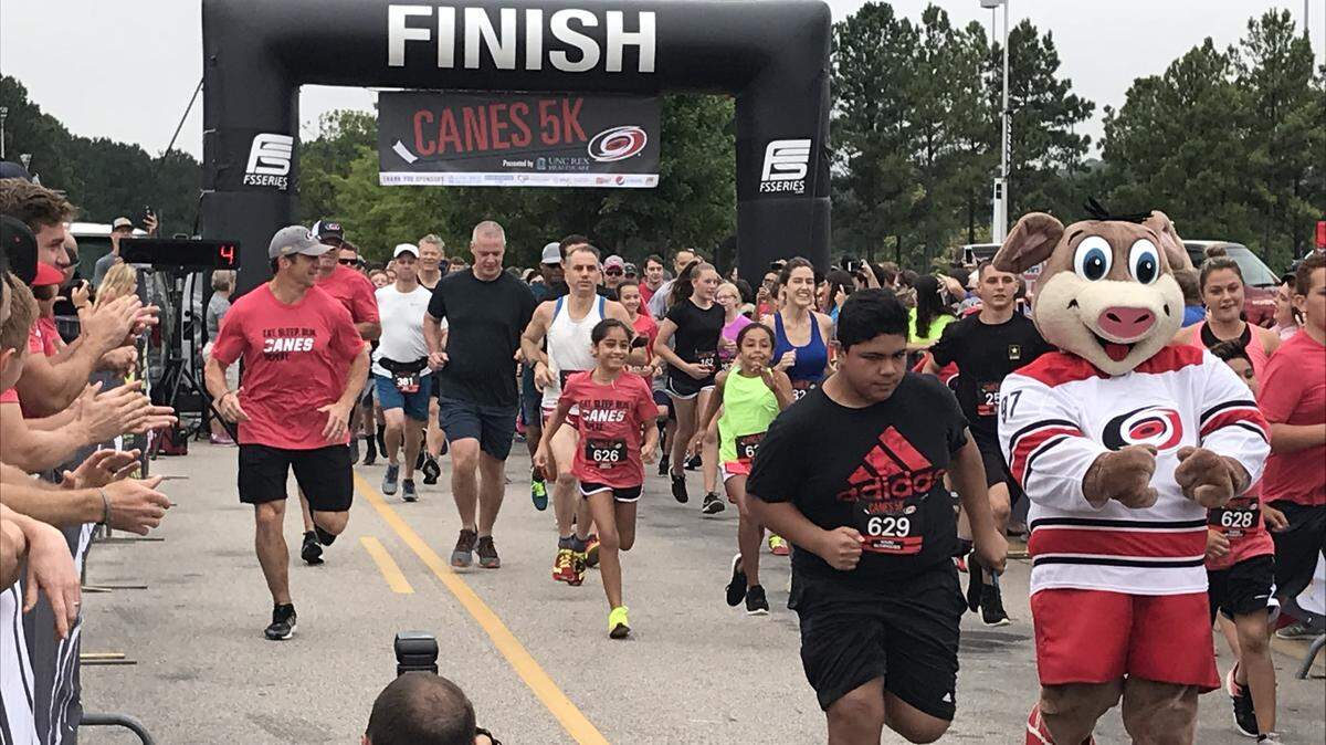 Carolina Hurricanes coach Rod Brind’Amour, left in red shirt, helps kick off annual Canes 5k charity run outside PNC Arena on Sept. 9, 2018. More than 800 runners participated.