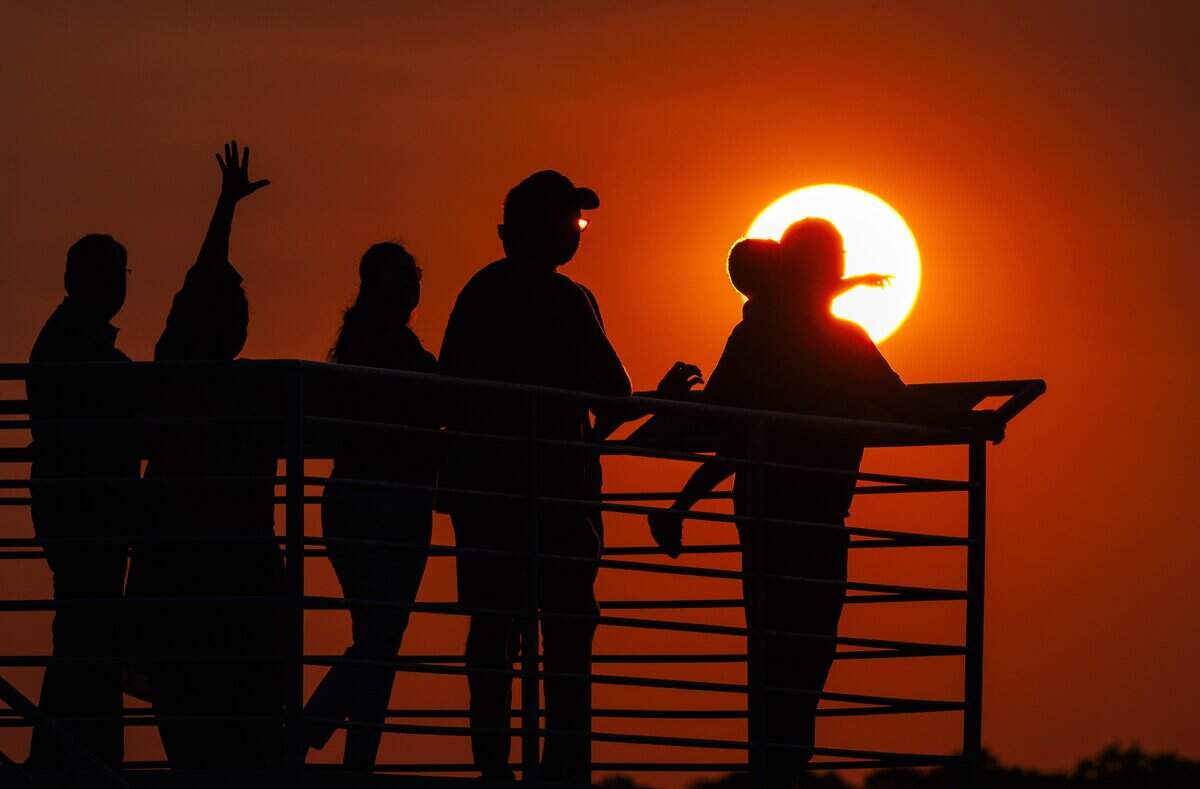Visitors to the Raleigh-Durham International Airport observation park watched as aircraft traveled down the runway during a vibrant sunset on Wednesday, July 15, 2026, in Morrisville, North Carolina.