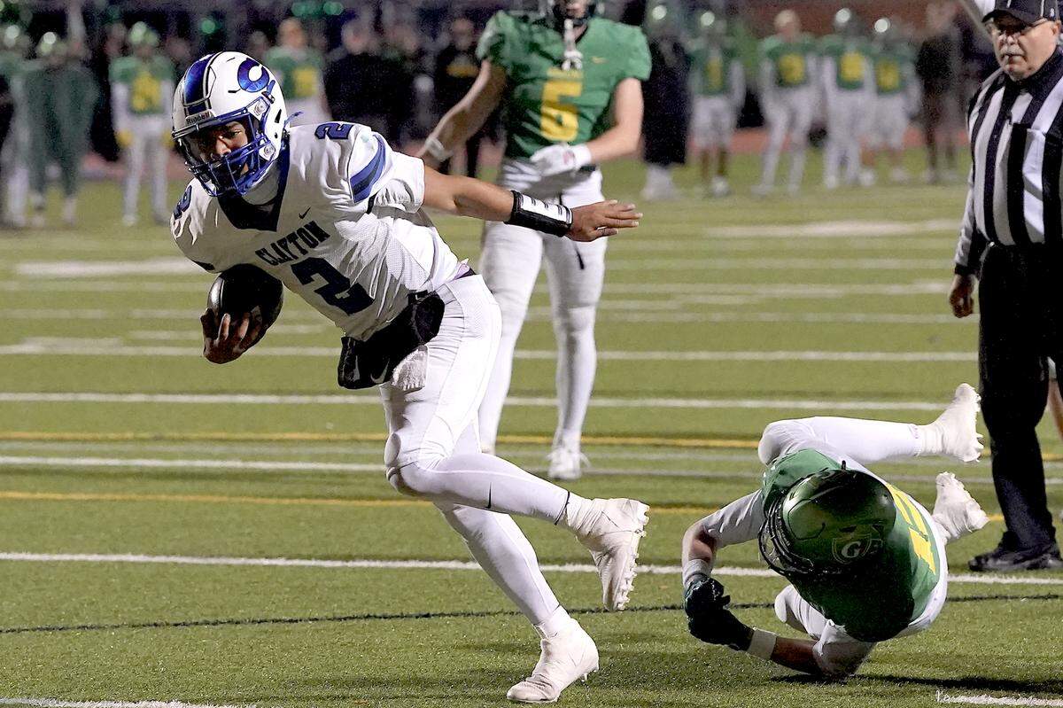 Clayton quarterback Aiden Smalls (2) runs for the touchdown against Cardinal Gibbons defensive back Drake Stone (12) during the second half. The Clayton Comets and the Cardinal Gibbons Crusaders met in the East Regional Final of the NCHSAA 7A Football Championship in Clayton, N.C. on December 4, 2025.