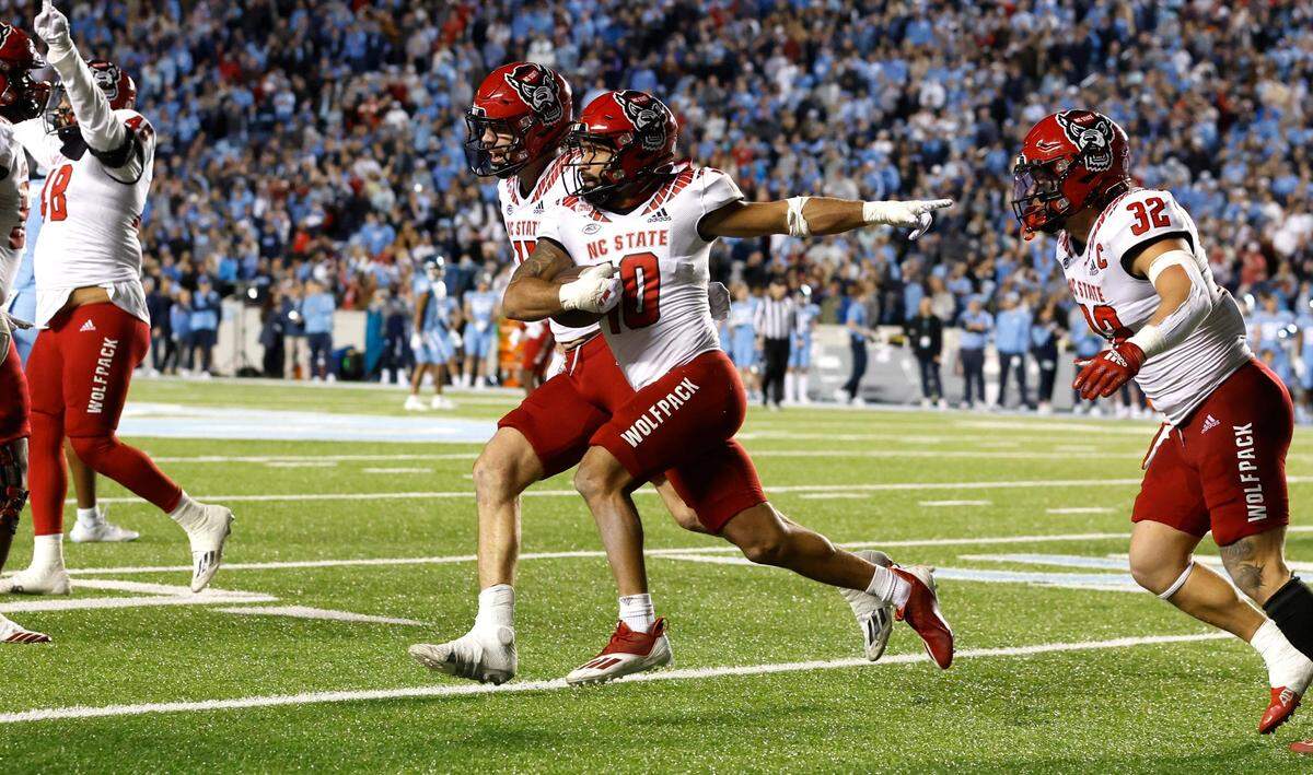 N.C. State linebacker Payton Wilson (11) celebrates with safety Tanner Ingle (10) after Ingle intercepted the ball during the second half of N.C. State’s 30-27 overtime victory over UNC at Kenan Stadium in Chapel Hill, N.C., Friday, Nov. 25, 2022.