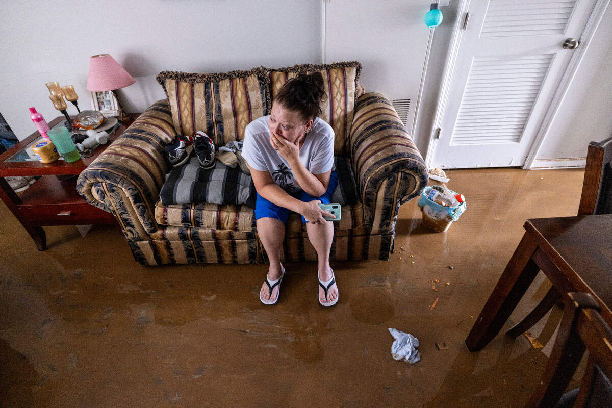 Jennifer Lyles, 46, is overwhelmed as she sits in the living room of her Rippling Streams Townhome in the Old Farm neighborhood along the Eno River in Durham on Monday morning, July 7, 2025, after flash flooding caused by Tropical Storm Chantal. Lyles said she was awakened by firefighters in a boat around 2:30 a.m.