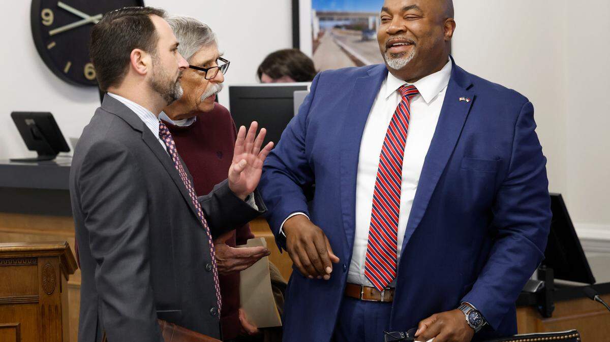 Bob Hall, longtime government accountability advocate, center, tries to talk with Lt. Gov. Mark Robinson after the Council of State meeting in Raleigh, N.C., Tuesday, Jan. 9, 2024. To the left is Brian LiVecchi, Robinson’s chief of staff.