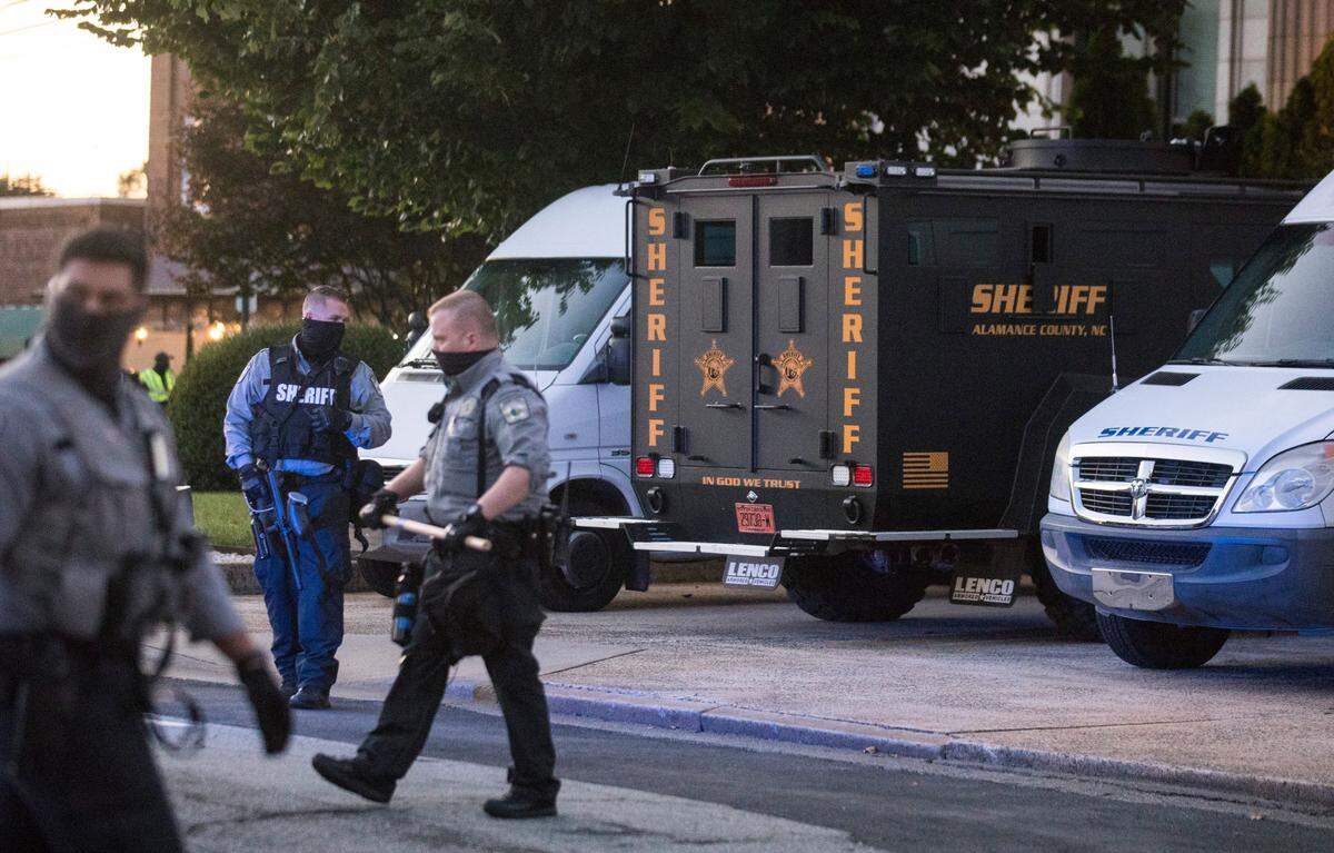 An armored vehicle can be seen outside the Alamance County Historic Courthouse as protesters march around Court Square on Saturday, Sept. 26, 2020.
