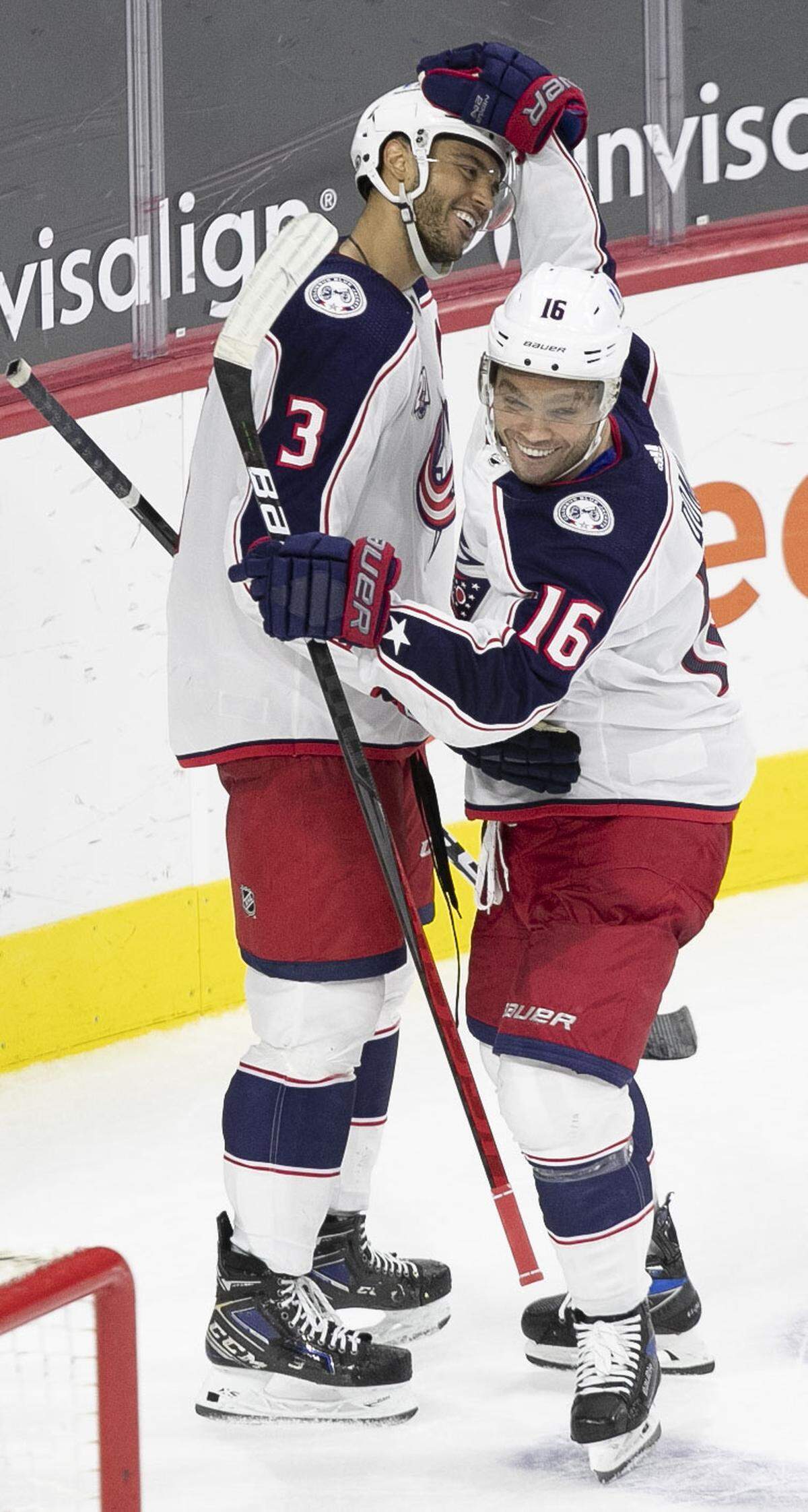 Columbus Blue Jackets’ Max Domi (16) embraces Seth Jones (3) after Jones scored the game winning goal in overtime to defeat the Carolina Hurricanes 3-2 on Thursday, March 18, 2021 at PNC Arena in Raleigh, N.C.