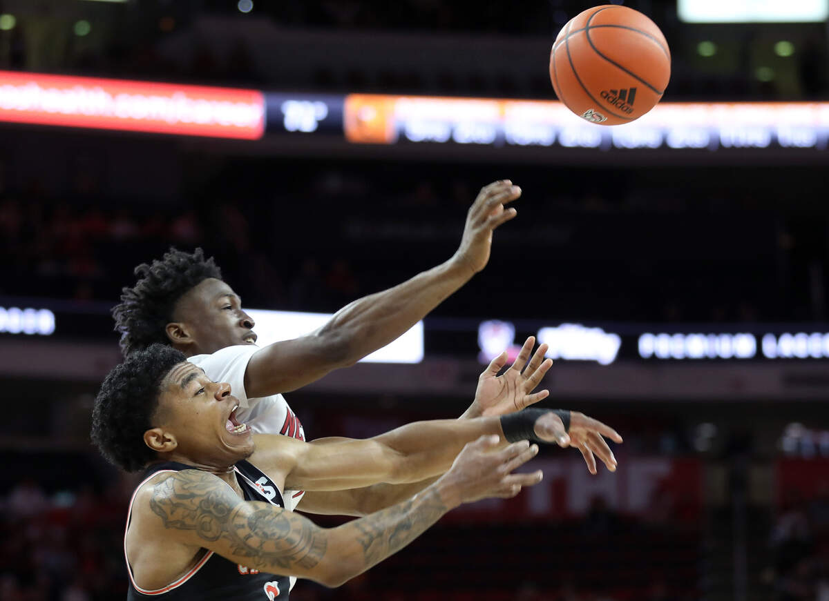 Campbell Fighting Camels guard Ricky Clemons and North Carolina State Wolfpack guard Jarkel Joiner lunge for a loose ball during the second half of a men’s basketball game at PNC Arena in Raleigh, N.C. on Friday, Nov. 11, 2022.