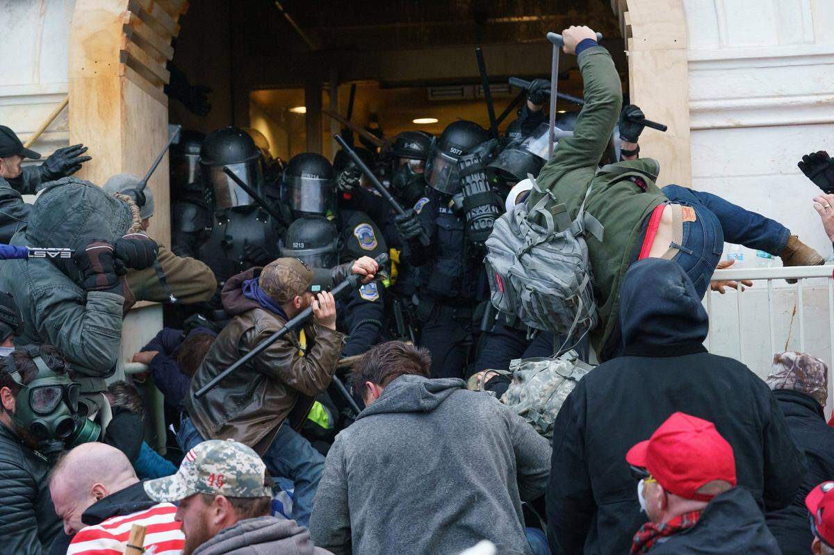 Supporters of President Donald Trump use bats, batons, and other items during a riot as they fight police defending an entrance to the U.S. Capitol on Jan. 6, 2021, in Washington, D.C.