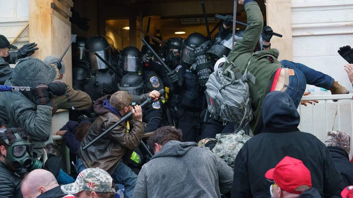 Supporters of President Donald Trump use bats, batons, and other items during as they fight police defending an entrance to the U.S. Capitol on Jan. 6, 2021.
