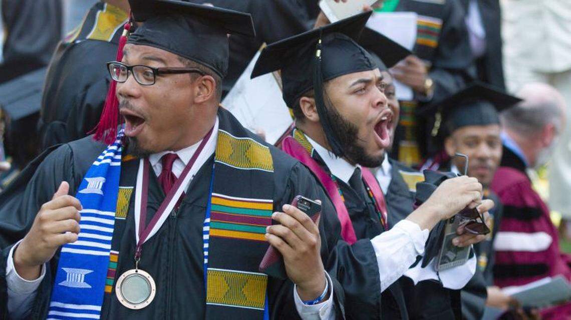 Caleb Barco, left, of Raleigh, reacts to Robert F. Smith’s announcement that the investor will pay off the loans of Morehouse College students at the school’s 2019 commencement.