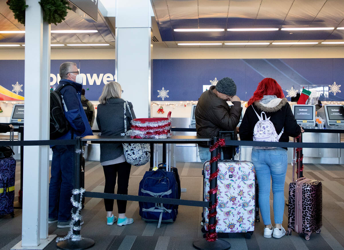 People wait in line at the Southwest ticketing counter on Tuesday, Dec. 27, 2022, at Raleigh-Durham International Airport.