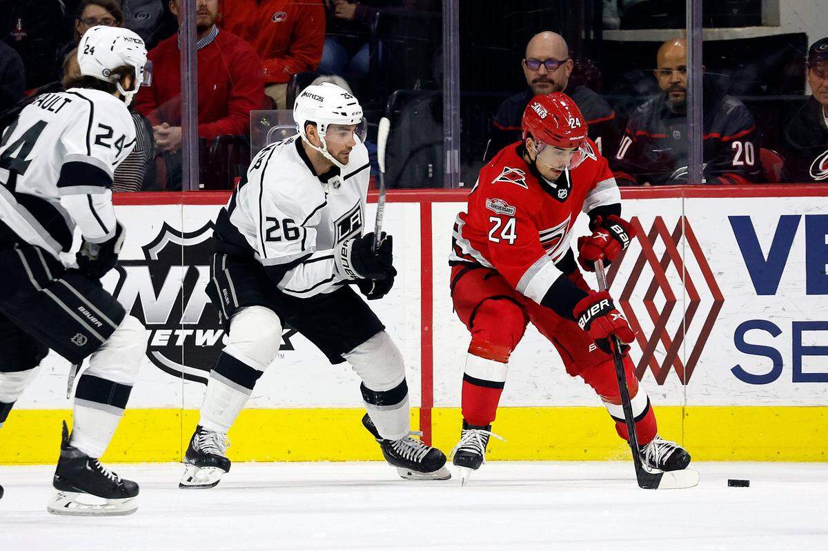Carolina Hurricanes’ Seth Jarvis (24) protects the puck from Los Angeles Kings’ Sean Walker (26) and Phillip Danault (24) during the first period of an NHL hockey game in Raleigh, N.C., Tuesday, Jan. 31, 2023. (AP Photo/Karl B DeBlaker)