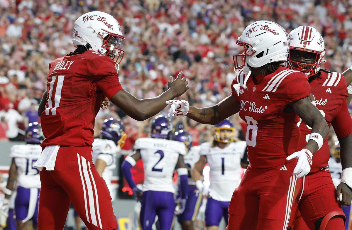 N.C. State quarterback CJ Bailey (11) celebrates with wide receiver Wesley Grimes (6) after Grimes scored on a 48-yard touchdown reception in the first half of N.C. State’s game against ECU at Carter-Finley Stadium in Raleigh, N.C., Thursday, August 28, 2025.