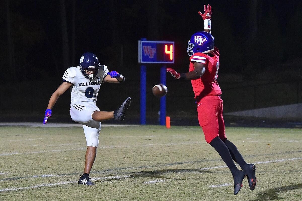 Wake Forest’s Nigel Lucas (1) attempts to block the punt from Millbrook’s David Santiago (8) during the second half. The Wake Forest Cougars and the Millbrook Wildcats met in a football game in Wake Forest, N.C. on October 28, 2022.