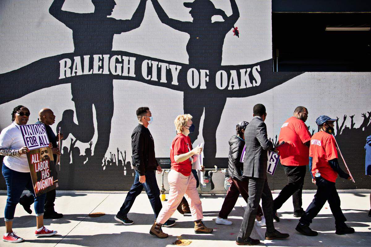 Protestors march outside of the Wake Forest & Six Forks Starbucks in Raleigh on April 11, 2022, in response to the firing of vocal union leader Sharon Gilman earlier this month.