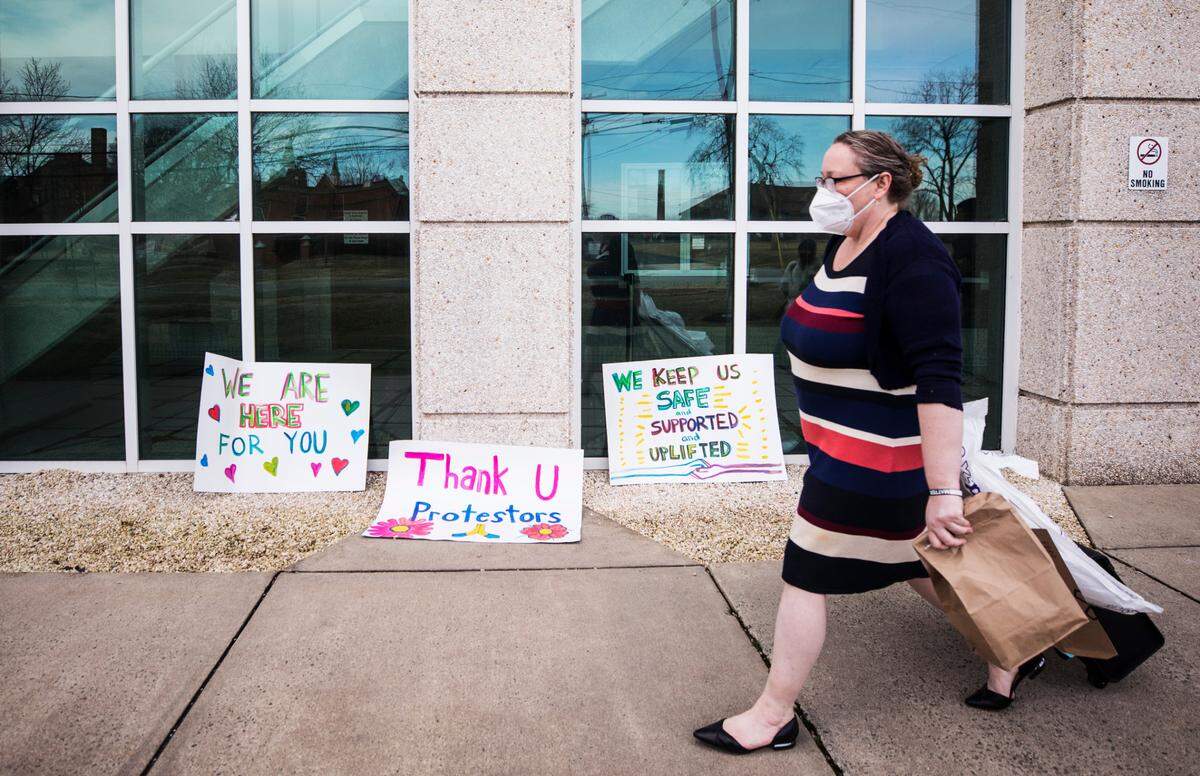 Attorney Jamie Paulen walks past signs of support for protesters facing charges as she makes her way to court hearings at the J.B. Allen Jr. Criminal Courthouse in Graham on Feb. 17, 2021.