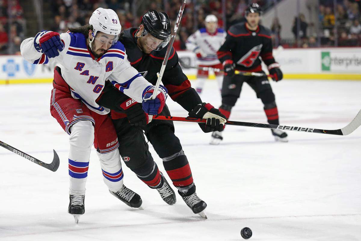 New York Rangers center Mika Zibanejad (93), of Sweden, and Carolina Hurricanes center Jordan Staal (11) skate for the puck during the first period of an NHL hockey game in Raleigh, N.C., Friday, Feb. 21, 2020. (AP Photo/Gerry Broome)