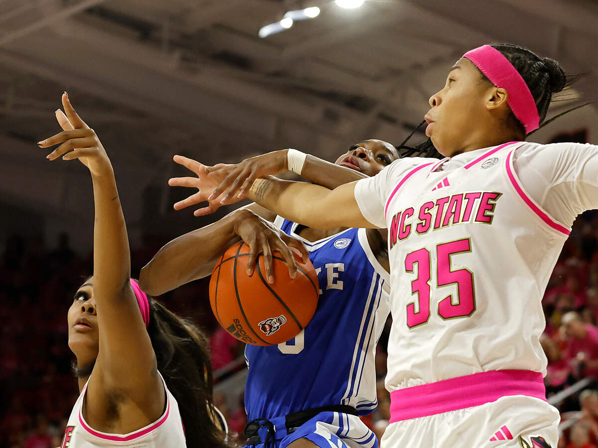 Duke’s Oluchi Okananwa pulls down a rebound between N.C. State’s Mallory Collier and Zoe Brooks during the first half of the Blue Devils’ 89-83 loss in the Play4Kay Game on Monday, Feb. 3, 2025, at Reynolds Coliseum in Raleigh, N.C.
