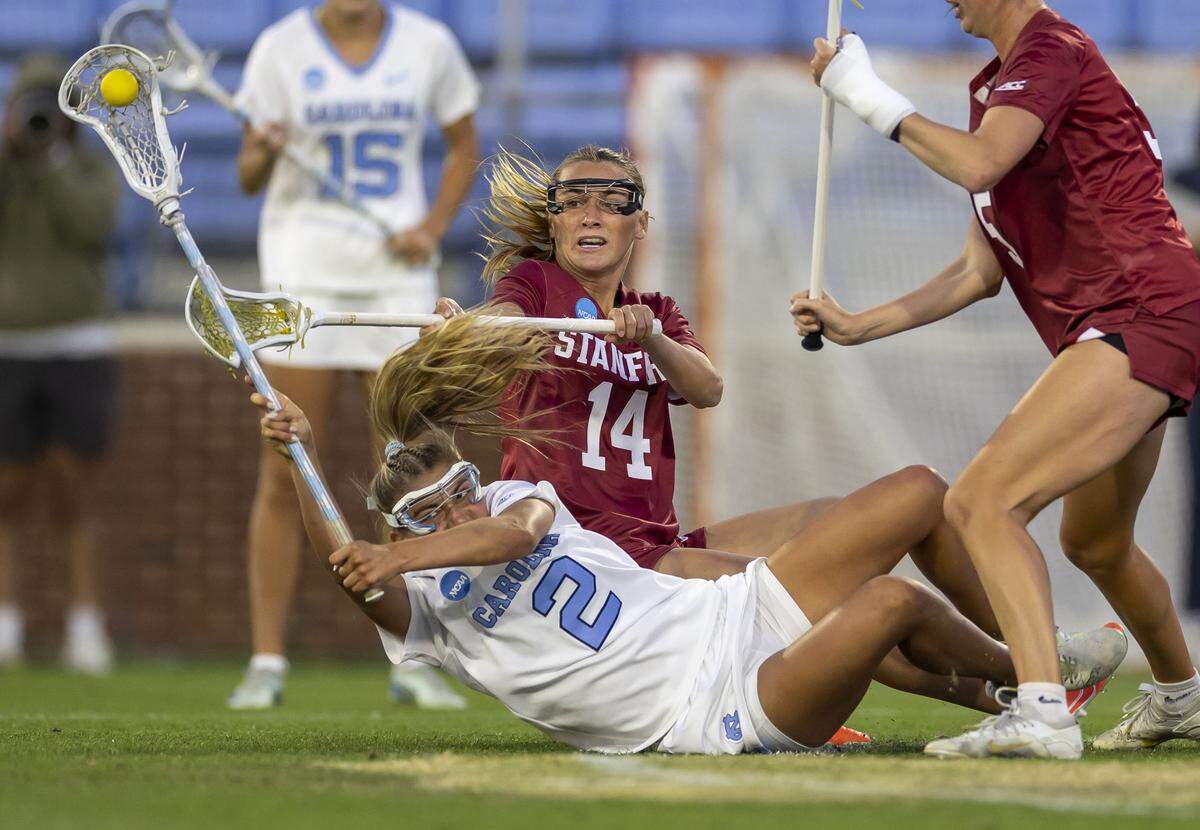 North Carolina attacker Chloe Humphrey (2) gets off a pass as he hits the turf under defensive pressure from Stanford midfielder Amanda Lawson (14) and defenseman Olivia Rose (5), during their NCAA quarterfinal matchup on Thursday, May 14, 2026 at Dorrance Field in Chapel Hill, N.C. The Tar Heels defeated Stanford 14-11.
