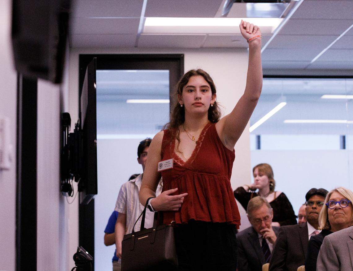 N.C. State junior Naila Din raises a fist while exiting a UNC System Board of Governors meeting on Thursday, May 23, 2024, in Raleigh, N.C. following the board’s approval of a policy that repeals DEI requirements across the university system.