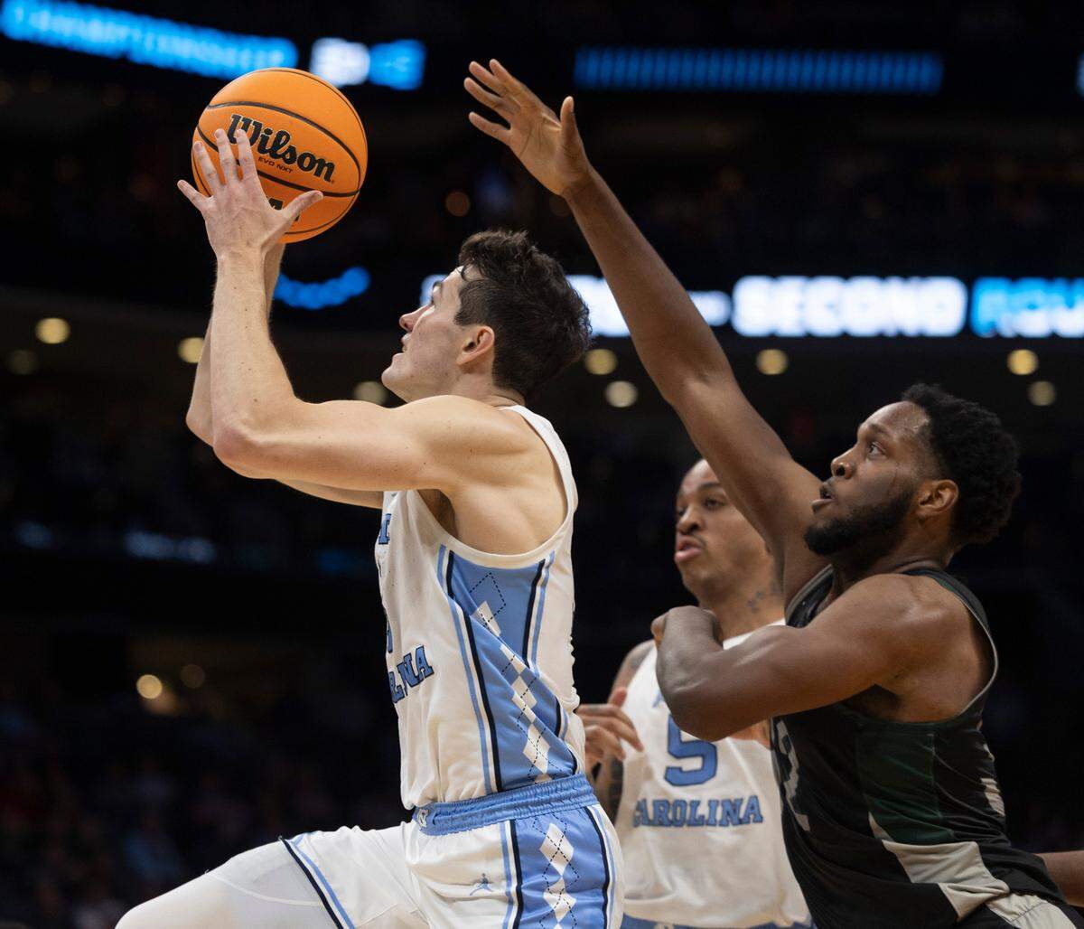 North Carolina’s Cormac Ryan (3) breaks to the basket past Wagner’s Keyontae Lewis (32) in the second half on Thursday, March 21, 2024 during the NCAA Tournament at Spectrum Center in Charlotte, N.C. Ryan scored 13 points in the Tar Heels’ victory.