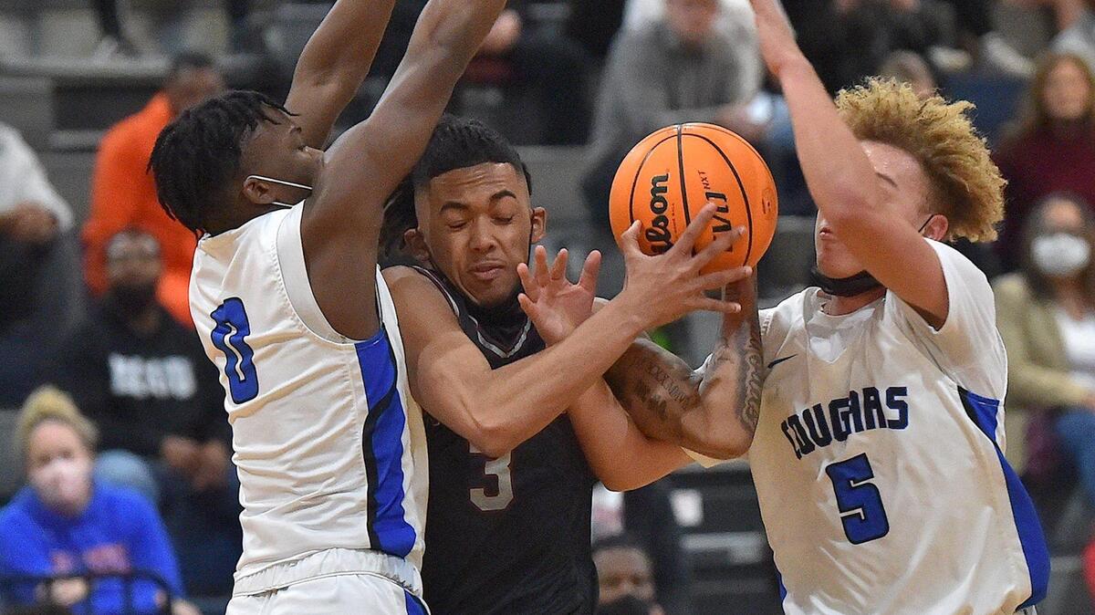 Wakefield’s Jamal Norris (3) drives to the basket between Wake Forest’s Jaden Valentine (0) and A.J. Smalls (5) during the first half. The Wakefield Wolverines and the Wake Forest Cougars met in a conference basketball game in Wake Forest, NC on January 14, 2022.