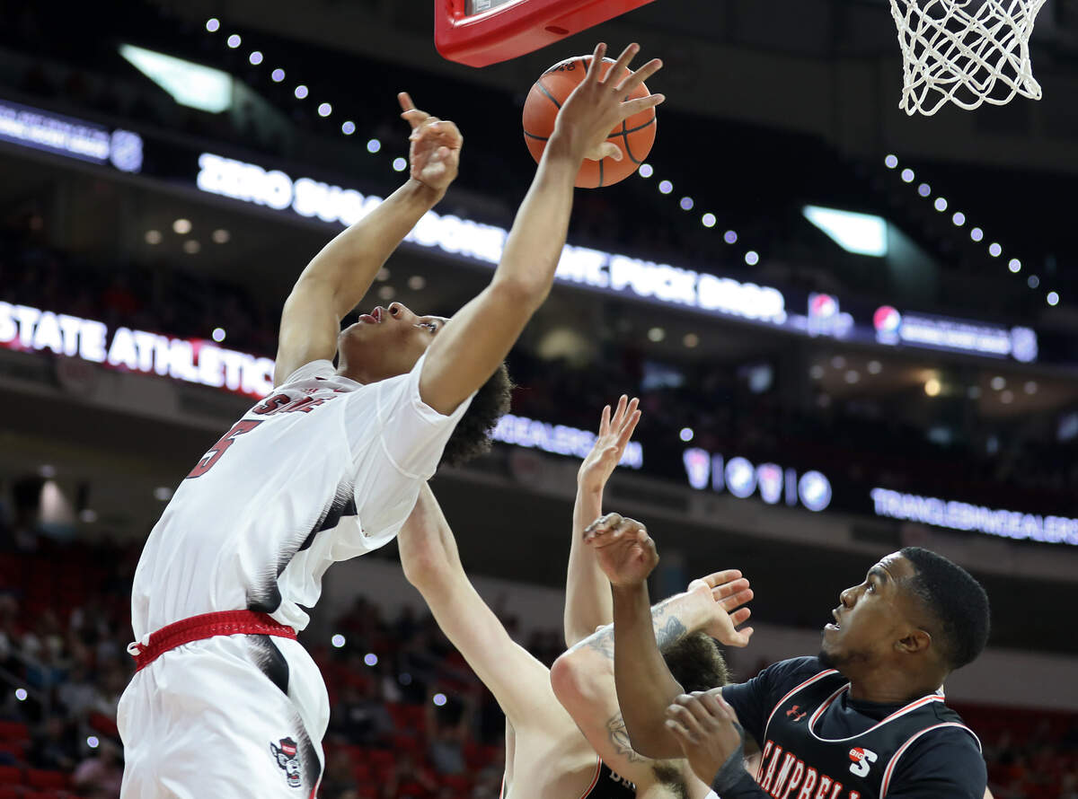 North Carolina State Wolfpack guard Jack Clark is fouled as he reaches for a rebound over Campbell’s Anthony Dell’Orso and Devon Dunn during the second half of a men’s basketball game at PNC Arena in Raleigh, N.C. on Friday, Nov. 11, 2022.