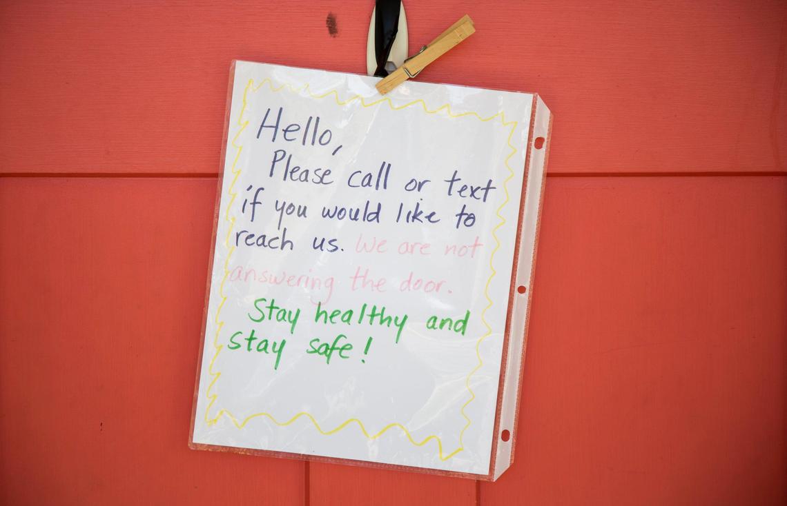 A sign on the door of Janie Desmond’s home reminds visitors to call or text, on Thursday, Apr. 16, 2020, in Durham, N.C. Desmond is one of many adults with disabilities who rely on support staff in their home to remain independent, but are worried that close interaction could increase the risk of contracting COVID-19.