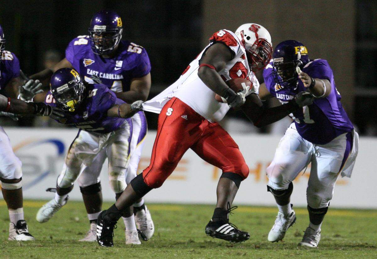 STATE7.SP.102007.EDH -- Greenville, NC -- October 20, 2007 -- N.C. State’s DeMario Pressley tries to avoid being tackled by ECU’s Chris Johnson, left, and Fred Hicks, right, after intercepting the ball in the fourth quarter during N.C. State’s 34-20 victory over ECU Saturday October 20, 2007, at Dowdy-Ficklen Stadium in Greenville, NC. Staff photo by Ethan Hyman/The News & Observer