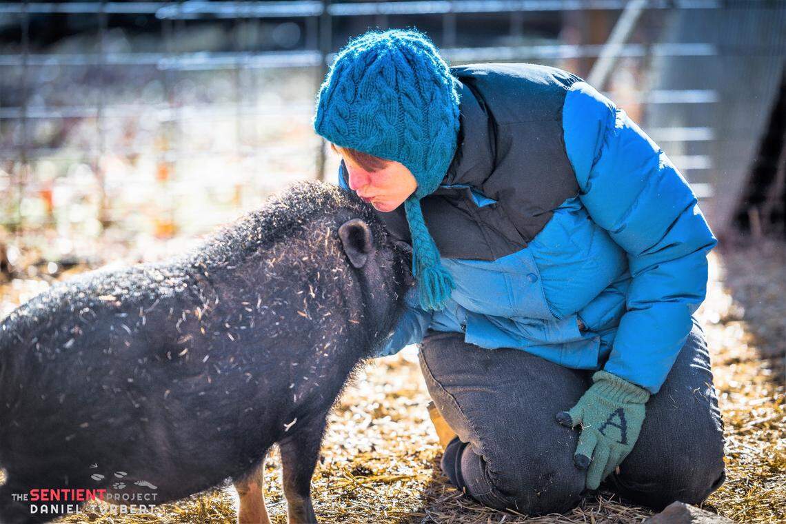 Anna O’Neal, founder of the Jenna and Friends Animal Sanctuary plants a kiss on Pedro the pig.